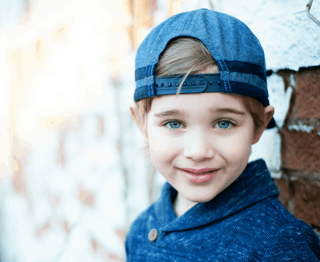 Foto van jongen met blauwe ogen, blauwe pet en blauwe trui - foto door Garrett Jackson via Unsplash
